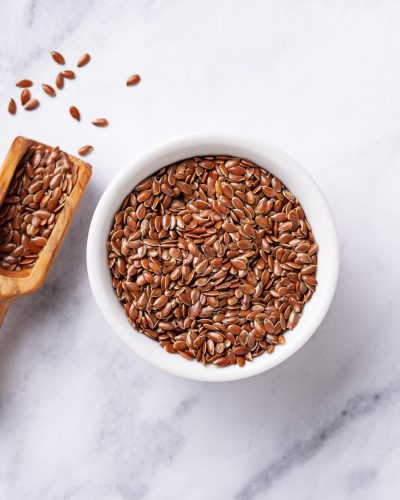 Flax seeds in bowl on marbled background